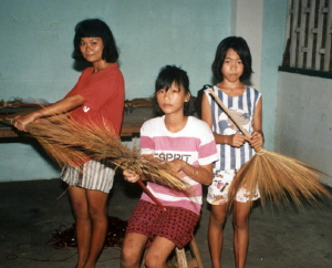Girld Making Brooms